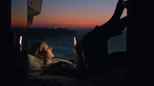 Woman with Phone in Van at Sunset Beach