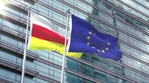 South Ossetia and European Union Flags Waving Against Modern Corporate Building