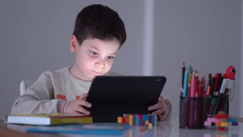 Young Boy Using Tablet at Table