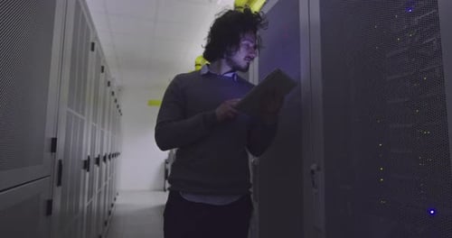 Man Uses Tablet in Data Center Server Room