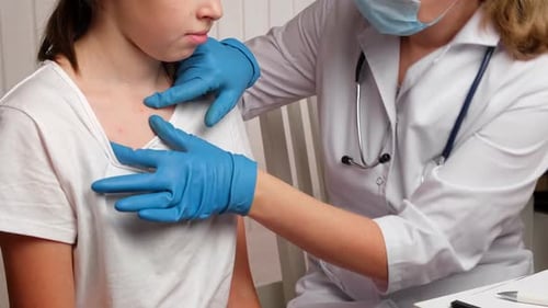 Doctor Examines Child with Spots in Clinic