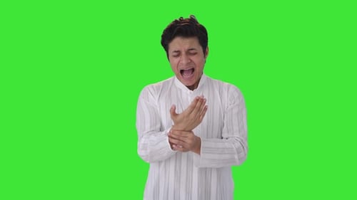 Sick Indian man suffering from hand pain Green screen