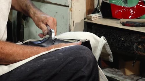 Sapateiro habilidoso que fabrica meticulosamente sapatos com ferramentas de precisão