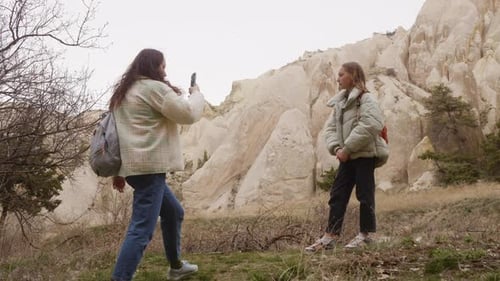 Girls Photographing Scenic Rock Formation on Overcast Day