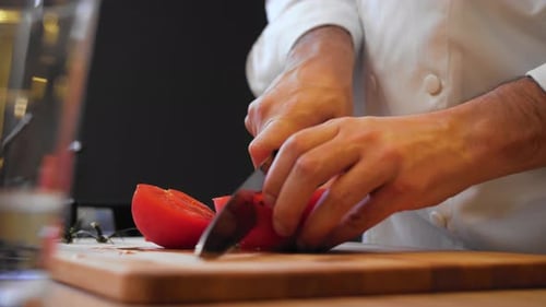 Chef Cutting Fresh Tomato on Wooden Cutting Board