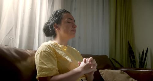 Jeune femme calme s'étirant assise sur un canapé Fille se relaxant sur le canapé les yeux fermés et