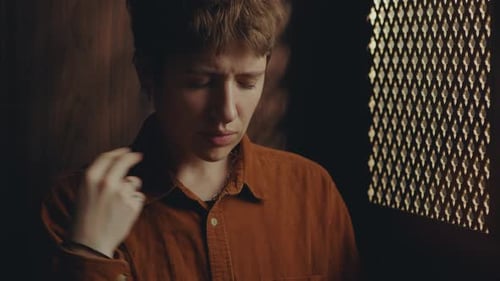 Young Faithful Woman Crossing Herself and Praying in Confessional Booth