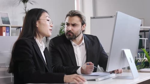 Diverse Colleagues Discussing Online Project in Office
