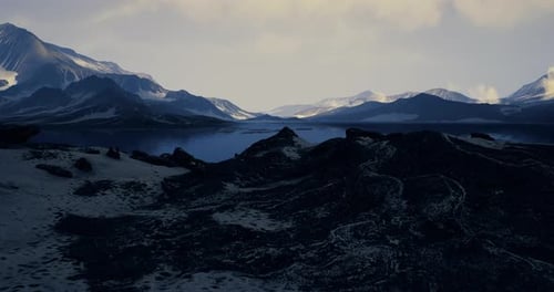 Majestic Mountain Landscape Reflecting Tranquil Waters Under Cloudy Sky