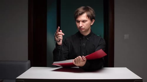 Young Adult Holding Rosary and Book Indoors