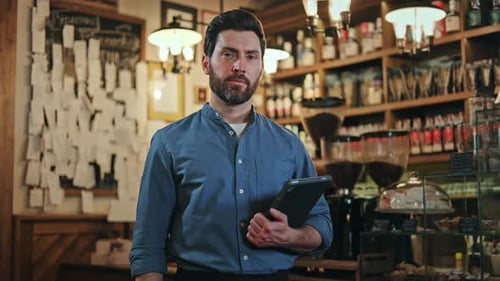 Portrait of Smiling Restaurant Manager Posing at Workplace with Tablet in Hands