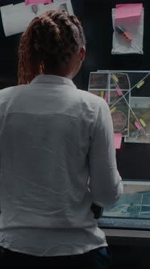 Serious Investigator Standing at Dark Evidence Board