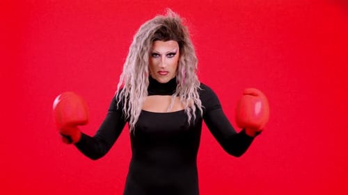 Drag Queen with Boxing Gloves Posing Against Red Backdrop