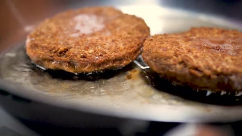 Fry Two Golden Brown Patties in a Frying Pan with Hot Oil in Slow Motion Beef Hamburger Cutlets are