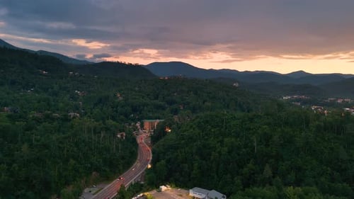 La avenida principal de Gatlinburg está bordeada de restaurantes iluminados, tiendas de recuerdos y montañas