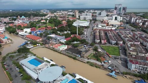 Aerial drone of a river in the city of Malacca Melaka Malaysia during a cloudy day track left shot