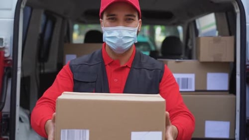 Young Delivery Man Holding Package in His Hands While Wearing Face Mask