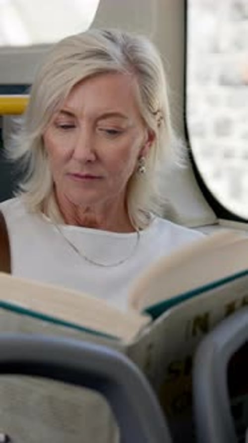 Woman Reads Book on City Bus