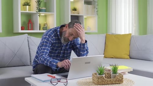 Stressed Man Working on Laptop at Home