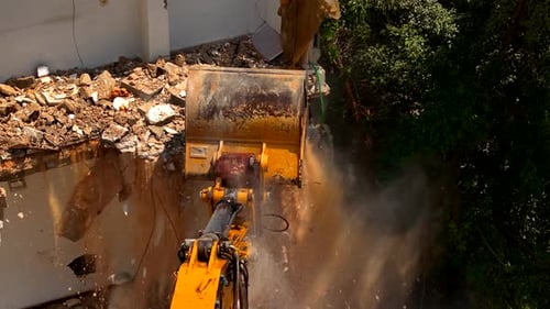 Excavator arm demolishing an old building, Aerial view