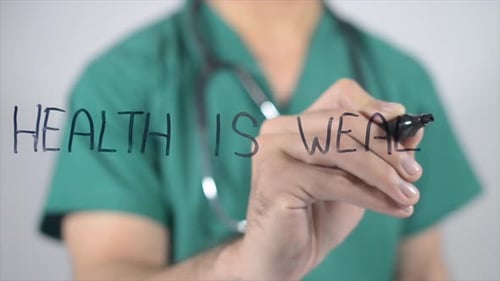 Medical Professional Writing Health is Wealth Message