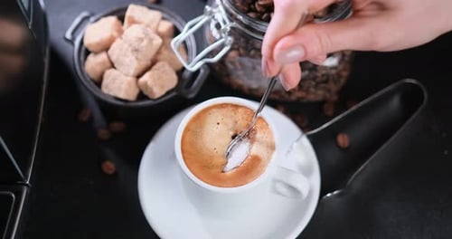 Hand Adding Sugar to Coffee and Stirring