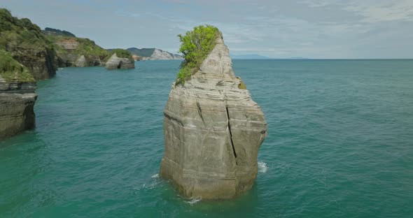 Natural limestone sea stack column near shore of New Zealand, aerial ...