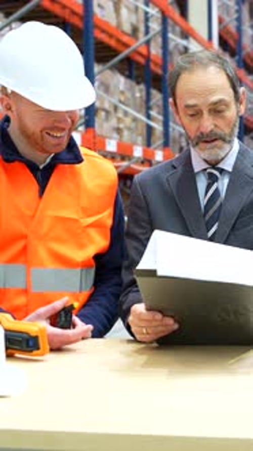Warehouse workers and manager reviewing inventory and logistics