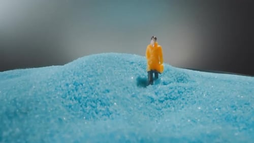 Figura de hombre de pie cerca de Sandy Heap sobre fondo gris