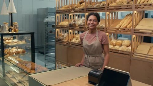 Portrait of Young Cheerful Female Worker in Bakery