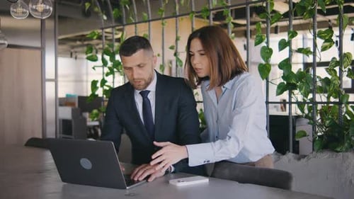 Business Professionals Collaborate Using Laptop in Modern Workplace