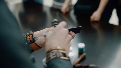 Artisan en cuir serrant un rivet sur un bracelet