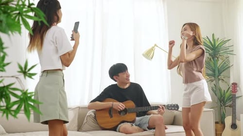 Friends Enjoy Music at Home on Couch