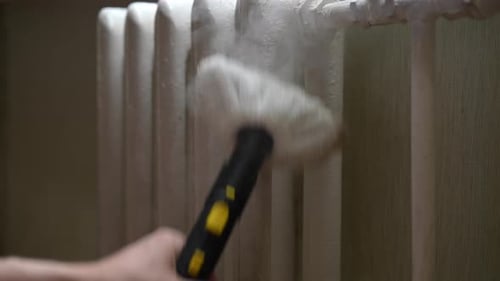 Cleaning Radiator with Modern Steamer Tool Indoors