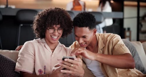 Young Men Laughing Together Looking at Mobile Phone