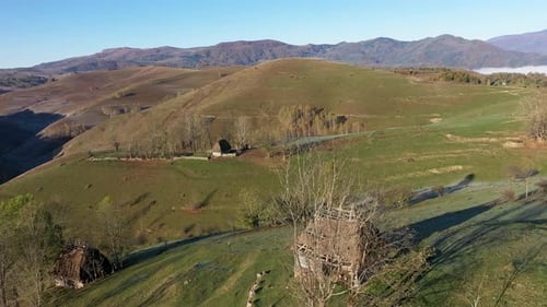 Vol au-dessus d'un refuge de montagne isolé rural en automne avec toit de chaume