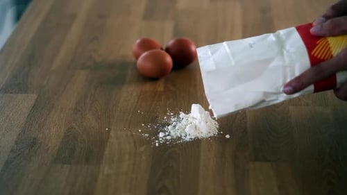Pouring Flour with Eggs on Kitchen Counter