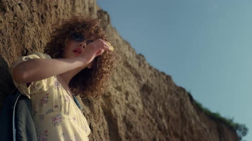 Glamour Seductive Model Standing Lighted Sunlight on Seashore Close Up. Curly Attractive