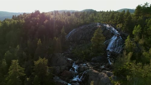 Mountain Waterfall Flowing Through Alpine Forest