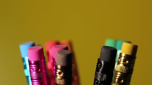 Colored Pencils Rotate On A Yellow Background, Stationery For School