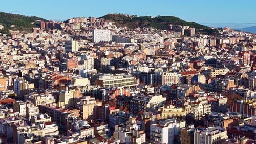 Dense hillside Barcelona cityscape with tightly located buildings under sunlight in Spain.