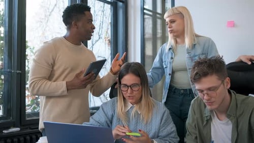 Diverse group of young business people working on new project together in office.