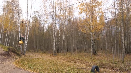 A Boy's Unsafe Descent on a Zip Line a Boy Rides a Zip Line in the Fall