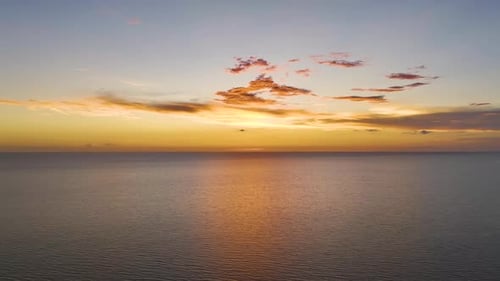 Dramático cielo rojo brillante en el océano, puesta de sol, suaves nubes vespertinas sobre el mar, agua oscura
