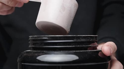 Protein Powder Being Scooped into a Container