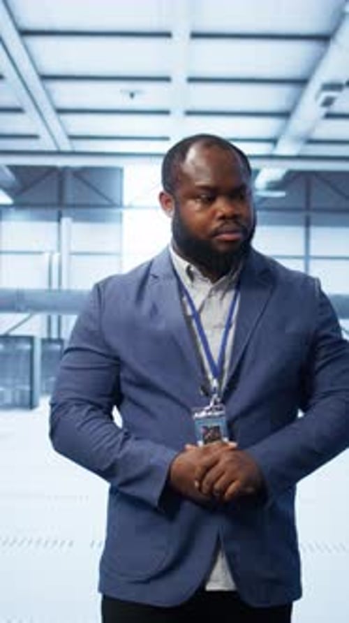 Vertical Video Technician Walking Between Server Rows in Data Center Doing Inspection