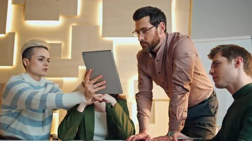 Professionals collaborating together around a table using tablet