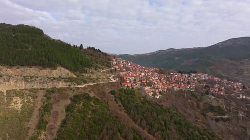 Aerial view of small town with red roofs and mountains, Greece.