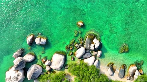 Stunning sandy beach with rock, clean sea water and green forest. 4K.