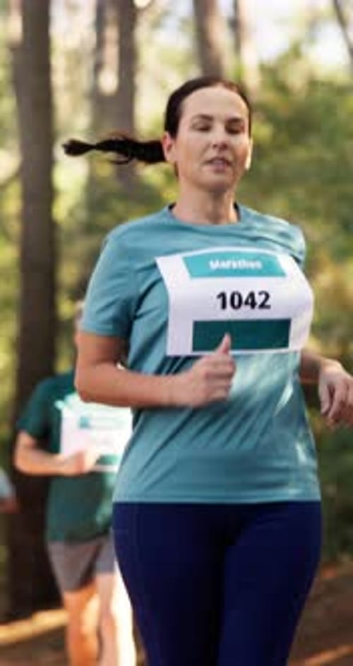 Marathon, woman and running competition in forest for fitness challenge, sports event and stamina